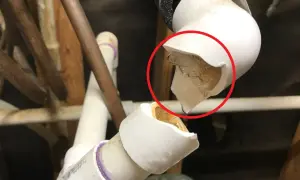 Pęknięta rura kanalizacyjna, widoczna w czerwonym okręgu, grozi zalaniem.