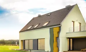 Przekrój ściany nowoczesnego domu pokazuje ocieplenie domu wełną mineralną, zapewniające komfort i energooszczędność.