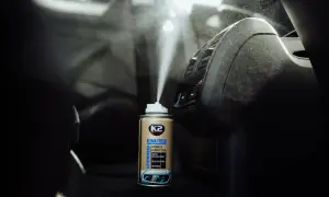 Pojemnik z preparatem K2 Klima Fresh w trakcie dezynfekcji klimatyzacji samochodowej, rozpylający mgiełkę.
