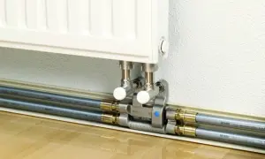 Estetyczne podłączenie grzejnika od dołu z wykorzystaniem nowoczesnych rur i rozdzielacza.