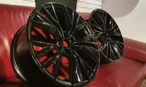 Eleganckie felgi po malowaniu proszkowym, z czerwonymi zaciskami w tle. Sprawdź nasz cennik!