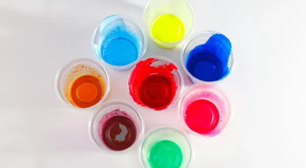 Kolorowe farby w kubeczkach, idealne jako jaka farba do plastiku na zewnątrz. Odcienie czerwieni, niebieskiego, żółtego, zielonego, pomarańczowego i różowego.