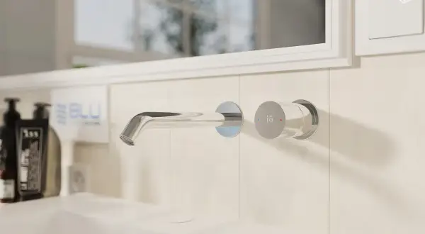 Elegancki montaż baterii prysznicowej w łazience. Chromowany kran wpuszczany w ścianę, obok pokrętło regulacji temperatury.
