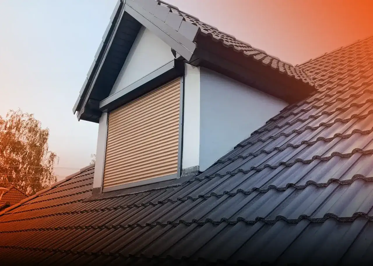 Nowe malowanie dachówki betonowej odświeżyło wygląd domu. Elegancka, ciemna dachówka i jasny rolety okienne.