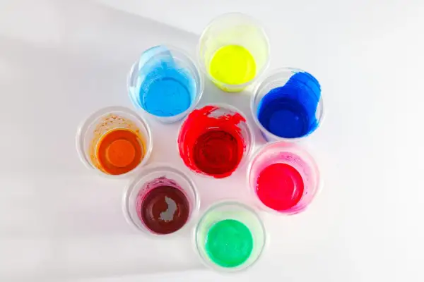 Kolorowe farby w kubeczkach, idealne jako jaka farba do plastiku na zewnątrz. Odcienie czerwieni, niebieskiego, żółtego, zielonego, pomarańczowego i różowego.